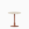 Round dining table with terrazzo top and metal pedestal base.
