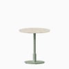Round dining table with terrazzo top and metal pedestal base.