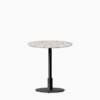 Round dining table with terrazzo top and metal pedestal base.