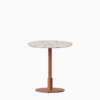 Round dining table with terrazzo top and metal pedestal base.