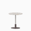 Round dining table with terrazzo top and metal pedestal base.