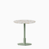 Round dining table with terrazzo top and metal pedestal base.
