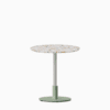Round dining table with terrazzo top and metal pedestal base.