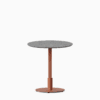 Round dining table with terrazzo top and metal pedestal base.