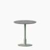 Round dining table with terrazzo top and metal pedestal base.