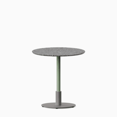 Round dining table with terrazzo top and metal pedestal base.