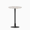Round bar table with terrazzo top and metal pedestal base.