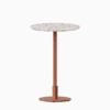 Round bar table with terrazzo top and metal pedestal base.
