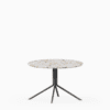 Round terrazzo table with speckled stone top and green aluminium base.