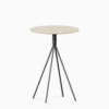 Round terrazzo bar table with speckled stone top and powdercoated aluminium base.