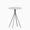 Round terrazzo bar table with speckled stone top and powdercoated aluminium base.